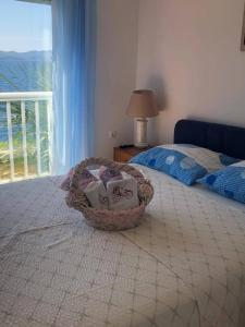 a bedroom with a basket on a bed with a window at Apartment Bonaca in Komarna