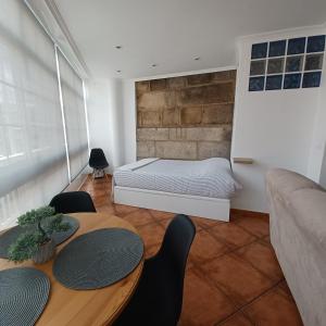 1 dormitorio con 1 cama, mesa y sillas en Loft Turístico, en Vigo