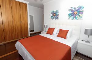 a bedroom with a large bed with orange pillows at Praia Mar (sea view) by STAY Madeira Island in Ponta do Sol