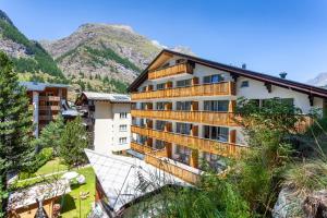 a large house with a large window overlooking a mountain range at Hotel Jägerhof in Zermatt
