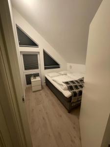 1 dormitorio con 1 cama y 2 ventanas en Barnevennlig feriehus ved sjøen en Kristiansand