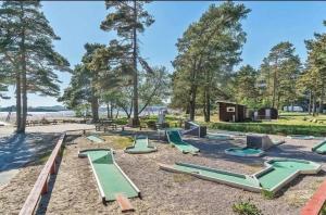 un parque infantil con toboganes verdes en la arena en Barnevennlig feriehus ved sjøen, en Kristiansand