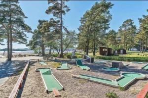 a playground with green slides in the sand at Barnevennlig feriehus ved sjøen in Kristiansand
