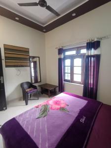a bedroom with a purple bed with a flower on it at Nature Villa in Rishīkesh