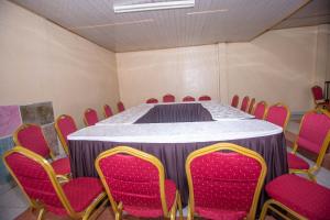 una sala conferenze con tavolo e sedie rosse di The Nest Guest House a Kericho
