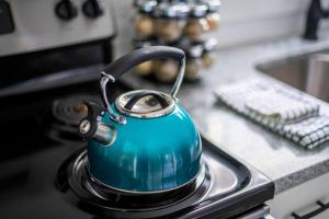 une théière assise sur une cuisinière dans l'établissement 2BR 1BA Duplex House King Beds Great for Small Groups Close to All Uptown Charlotte attractions, à Charlotte