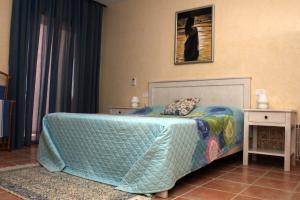 um quarto com uma cama com um edredão azul em Casa Mia em Ouled Kacem
