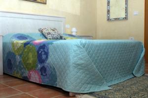 Una cama con una manta en una habitación en Casa Mia, en Ouled Kacem