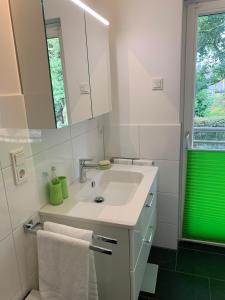 a white bathroom with a sink and a mirror at bike & chill in Kleve