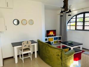 a living room with a couch and a table and a tv at Safi Neat & Cozy Suite in East London