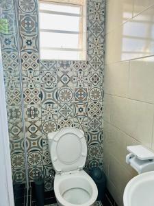 a small bathroom with a toilet and a window at Safi Neat & Cozy Suite in East London