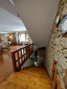 a staircase with a stone wall and a clock on a wall at casa na aldeia - entre Fundão e Covilhã in Pêro Viseu
