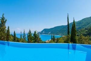 a swimming pool with a view of a lake and mountains at Milos Mountain - Villa Nikitas in Agios Nikitas