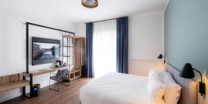 um quarto de hotel com uma cama e uma televisão em The Foscarini em Mogliano Veneto