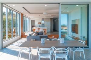 a dining room and living room with a table and chairs at Quinta do Charco in Ribeira Grande