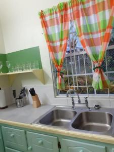 a kitchen with a sink and a window at Juju's Cottage with magnificent views in Laborie
