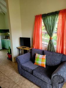 a living room with a purple couch and a window at Juju's Cottage with magnificent views in Laborie