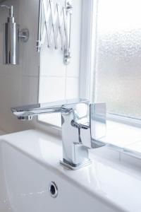 a bathroom sink with a faucet and a mirror at Lancefield House - Spacious 5 Bedroom - Sleeps 15 in Walton on the Hill +25 photos