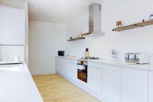 a white kitchen with white counters and white appliances at Lancefield House - Spacious 5 Bedroom - Sleeps 15 in Walton on the Hill