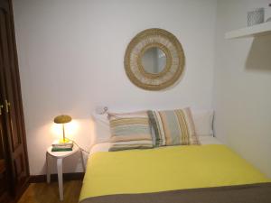 a bedroom with a yellow bed and a mirror at Casa Riera * En el centro de Oviedo, terraza, 2Hab in Oviedo