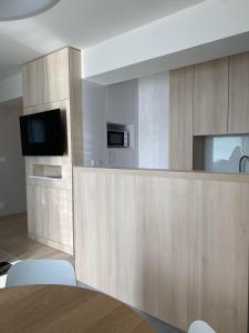 a kitchen with wooden cabinets and a counter with a tv at Apartman Hestia in Rajecké Teplice