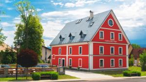 a red house with a gray roof at Liptovský mlyn in Bešeňová