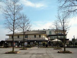 Caerano di San Marco的住宿－王冠酒店，前面有树木的大建筑