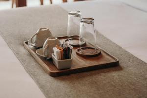 - un plateau avec des verres et des ustensiles sur une table dans l'établissement Queen at Gunung Sari, à Ubud