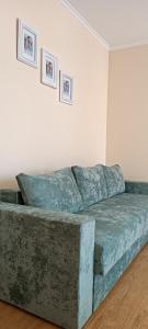 um sofá num quarto com duas fotografias na parede em VIP Apartments in the Centre em Mukacheve