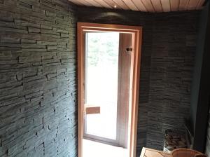eine Glastür in einer Ziegelwand mit einem Fenster in der Unterkunft Roheluse metsamaja with hot tub and sauna 