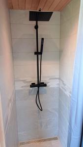 um chuveiro com uma cabeça de chuveiro em Roheluse metsamaja with hot tub and sauna 