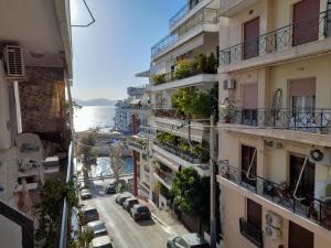 an apartment building with cars parked on a street at Casa Nova - Appartment near the sea in Piraeus