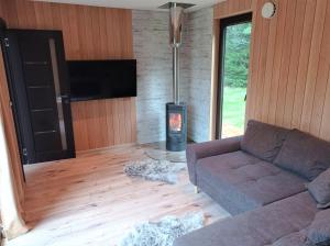 a living room with a couch and a wood stove at Roheluse metsamaja with hot tub and sauna 