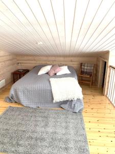 Cama en habitación con techo blanco en VillaRiutta Ruka, en Kuusamo