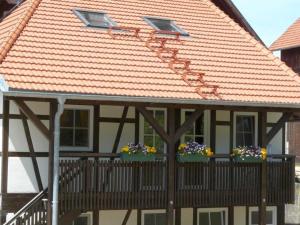 ein Haus mit Blumenkästen auf einem Balkon in der Unterkunft Hofgut Uhenfels in Seeburg