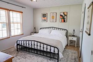 a bedroom with a bed and two windows at Beautiful Stylish 3 bedroom home in Greenville in Greenville