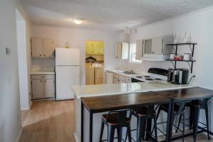 a kitchen with a table and a white refrigerator at Beautiful Stylish 3 bedroom home in Greenville in Greenville +11 photos