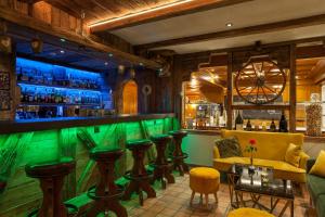 a bar at a restaurant with green bar stools at Jägerhof Serviced Apartements in Zermatt
