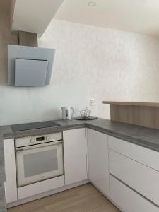 a kitchen with white cabinets and a counter top at Apartman Hestia in Rajecké Teplice