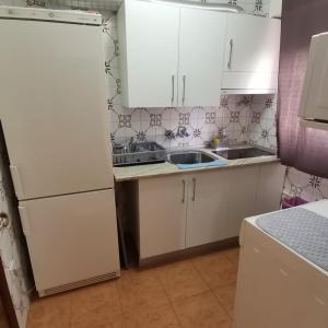 a kitchen with white cabinets and a sink at Casa Rural El Rincon del descanso in Yebra