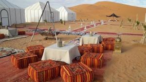a group of tables and chairs in the desert at Camp Sahara berber in Merzouga