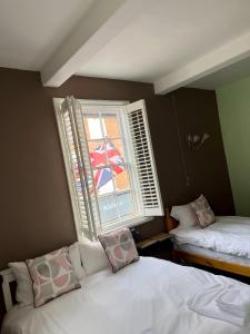 a small room with two beds and a window at The Crown Hotel in Southwell