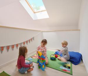 dos niños jugando con juguetes en una habitación en The wood house/La Maison Bois, en Montembœuf