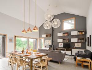uma sala de jantar e sala de estar com mesa e cadeiras em The wood house/La Maison Bois em Montembœuf