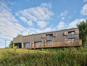 Montembœuf的住宿－The wood house/La Maison Bois，木板房子,在田野上设有甲板