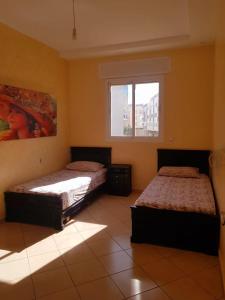 2 Betten in einem Zimmer mit Fenster in der Unterkunft Dar Sara in Asilah