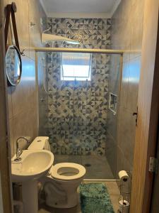 a bathroom with a shower and a toilet and a sink at Casa para aluguel de temporada em Caraguatatuba, ao lado de São Sebastião in Caraguatatuba