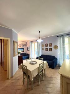 een woonkamer met een tafel en een blauwe bank bij Sapore di sale, Capo D’Orlando in Capo dʼOrlando