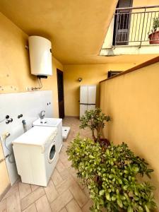 y baño con aseo, lavabo y algunas plantas. en Sapore di sale, Capo D’Orlando, en Capo dʼOrlando