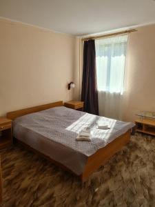 1 dormitorio con 1 cama con 2 toallas en Laine guesthouse en Narva-Jõesuu